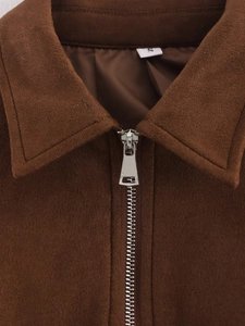 Dettaglio collo giacca in camoscio marrone con zip in metallo ed etichetta S