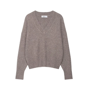 Close-up of soft taupe V-neck knit sweater showing ribbed cuffs and fine wool texture