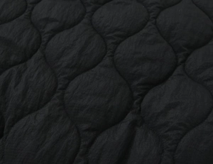 Detailed close-up showing the premium black wavy onion quilting on a padded winter jacket