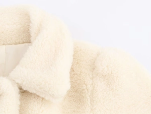 Detail of soft cream faux fur jacket showing fluffy texture and premium lapel lining