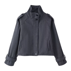 Detail of dark grey wool jacket featuring a stand collar, shoulder straps, and zip-up closure