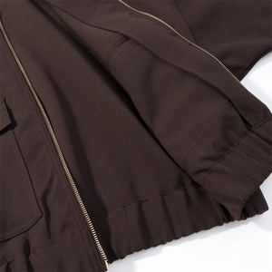 Detail view of coffee brown casual jacket showing smooth fabric and metal zipper closure