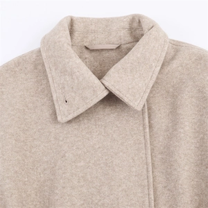 Detail of oat-colored wool coat featuring refined collar design and quality stitching