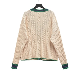Classic cream cable knit cardigan with green and blue striped trim in preppy style