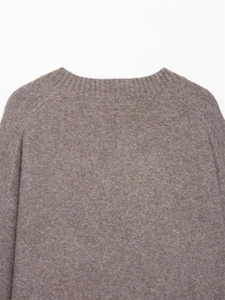 Detailed close-up of brown V-neck knit sweater showing collar and shoulder texture