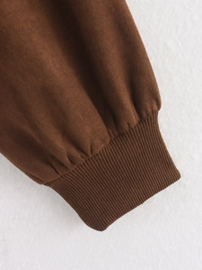Detail of dark brown suede jacket featuring tight ribbed cuffs and soft fabric texture