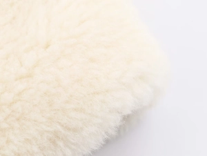 Macro shot of high-density white faux fur texture on a waist-belted winter jacket