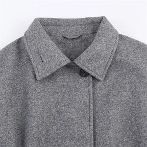 Macro detail of dark grey wool blend coat featuring classic lapel and a single brown button