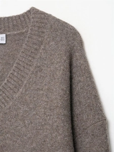 Detailed close-up of V-neck collar and soft knit texture on dark brown sweater