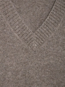 Macro view of the ribbed V-neckline and soft wool texture of this knit sweater