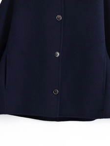 Detail of dark blue wool jacket featuring three brown buttons and premium seam craft