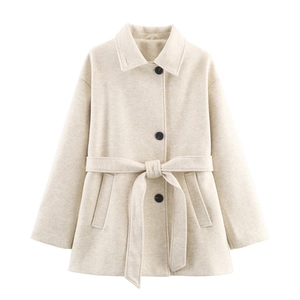 Detailed view of apricot wool coat featuring classic lapels and black contrast buttons