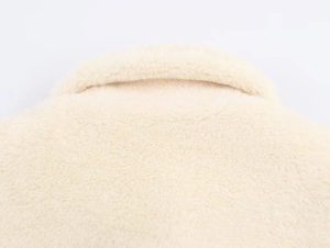 Close-up detail of soft beige faux fur collar texture on this winter waist-tie jacket
