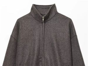 Detail of dark grey zip-up jacket collar and texture with silver metal zipper