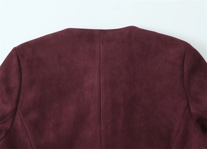 Macro shot of burgundy faux suede texture and stitching detail on jacket collar