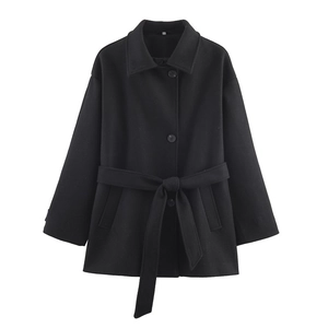Detail of black wool coat featuring double-layer collar and stylish button closure