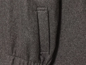 Detail of high-quality dark grey wool jacket fabric and the vertical welt pocket stitching