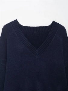 Detail of V-neckline with ribbed trim and soft knit texture on navy blue sweater