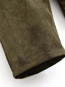 Detailed close-up of dark olive faux suede fabric texture and reinforced seam stitching