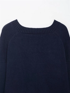 Detail view of the navy blue knit sweater featuring a ribbed V-neckline and raglan sleeves