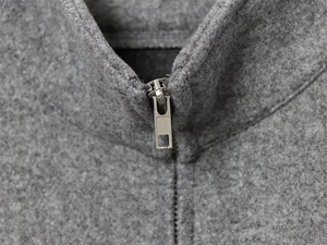 Detailed view of the sleek metal zipper and textured fleece high collar on a gray jacket