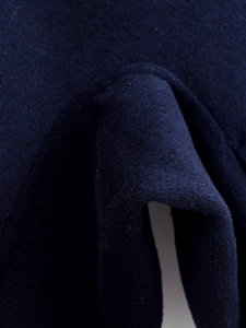 Macro shot of dark blue wool blend fabric texture showing thick fiber material quality