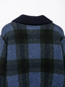 Detail of ribbed knit neckline and fuzzy plaid texture on blue and green sweater
