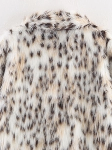 Detail shot of the plush faux fur texture with leopard spot patterns on the coat