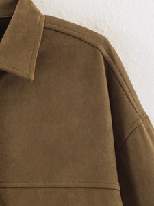 Detail view of high-quality stitching and suede texture on a brown jacket collar