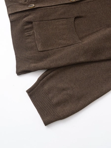 Detail of dark brown knit cardigan with ribbed cuffs and tortoise shell buttons