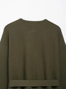 Detail eines armeegrünen Strickpullovers mit Rundhalsausschnitt und feiner Textur
