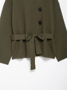 Detail der olivgrünen Strickjacke mit großen braunen Knöpfen und Taillengürtel