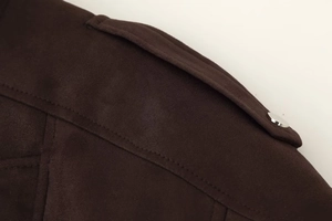 Detail of dark brown suede jacket shoulder featuring silver metal snap and stitch work
