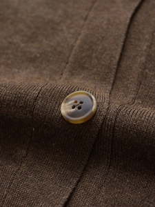 Detailed close-up of brown knit fabric texture and premium amber-patterned button detail