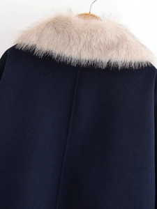 Detail of navy blue wool coat featuring a soft beige faux fur collar and premium texture
