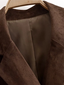 Detailed macro view of premium brown suede jacket fabric and smooth silk lining on hanger