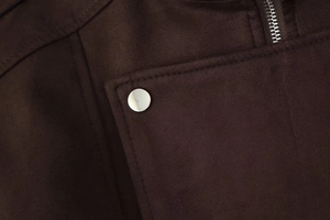 Detailed macro view of silver metal buttons and fine stitching on dark brown suede jacket
