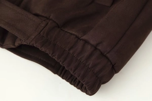 Detailed macro view of dark brown faux suede jacket with elastic ribbed cuff and neat stitching