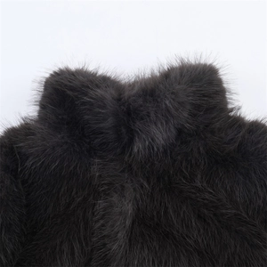 Gros plan sur la texture en fausse fourrure noire et les fibres denses du col du manteau
