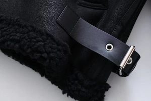 Detail von Kunstledertextur und Fleece-Futter mit Silberschnalle an schwarzer Jacke