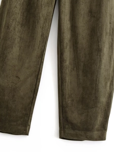 Detail van olijfgroene suède-look broek met zoomstiksels en zachte textuur van de stof