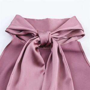 Détail macro du col licou et de la texture satinée soyeuse de ce haut élégant rose poudré