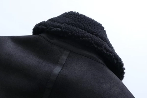 Detailansicht von schwarzem Lammfellkragen und Wildledertextur an Fleecejacke