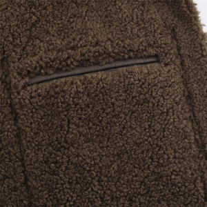 Vue macro de la texture moutonné marron foncé avec poche à bordure en cuir
