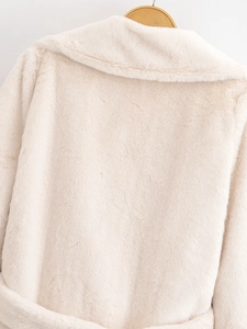Close-up of soft beige faux fur coat texture showing high-quality plush material back