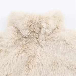 Gros plan sur la texture douce en fourrure synthétique beige d'un manteau d'automne