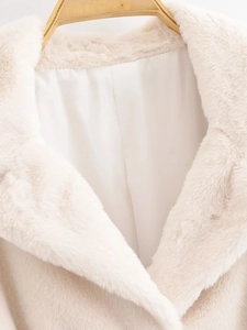 Close-up of plush faux fur texture and smooth silk lining on beige winter coat