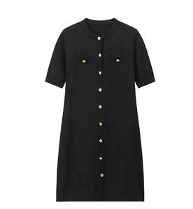 Detail of black knit dress featuring elegant gold embossed buttons and symmetrical pockets