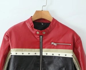 Detail of red and beige PU biker jacket showing silver studs and zipper on chest