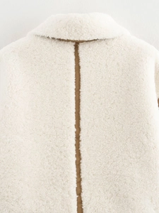 Détail de couture contrastée brune sur le col d'une veste en polaire blanc ivoire
